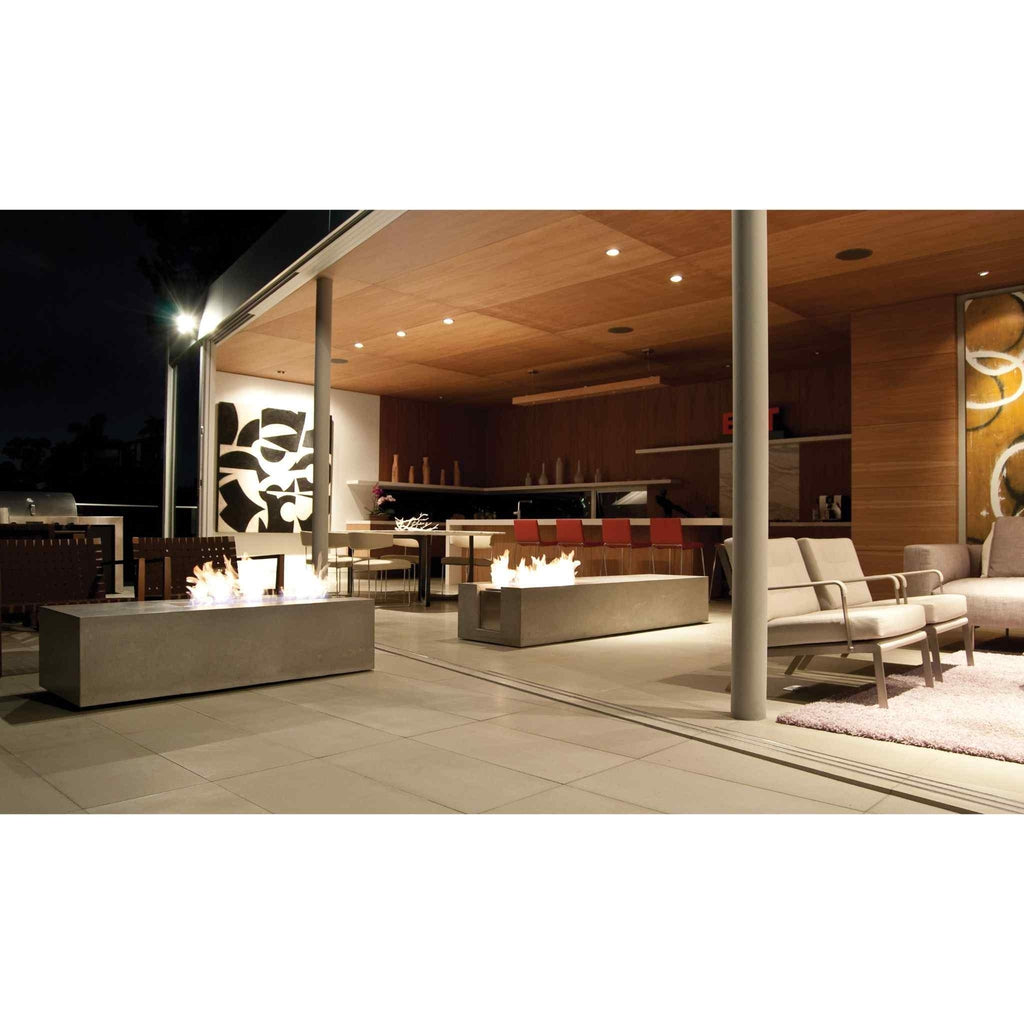 Two rectangular concrete EcoSmart Fire XL700 ethanol burners with flames on a modern outdoor patio at night.