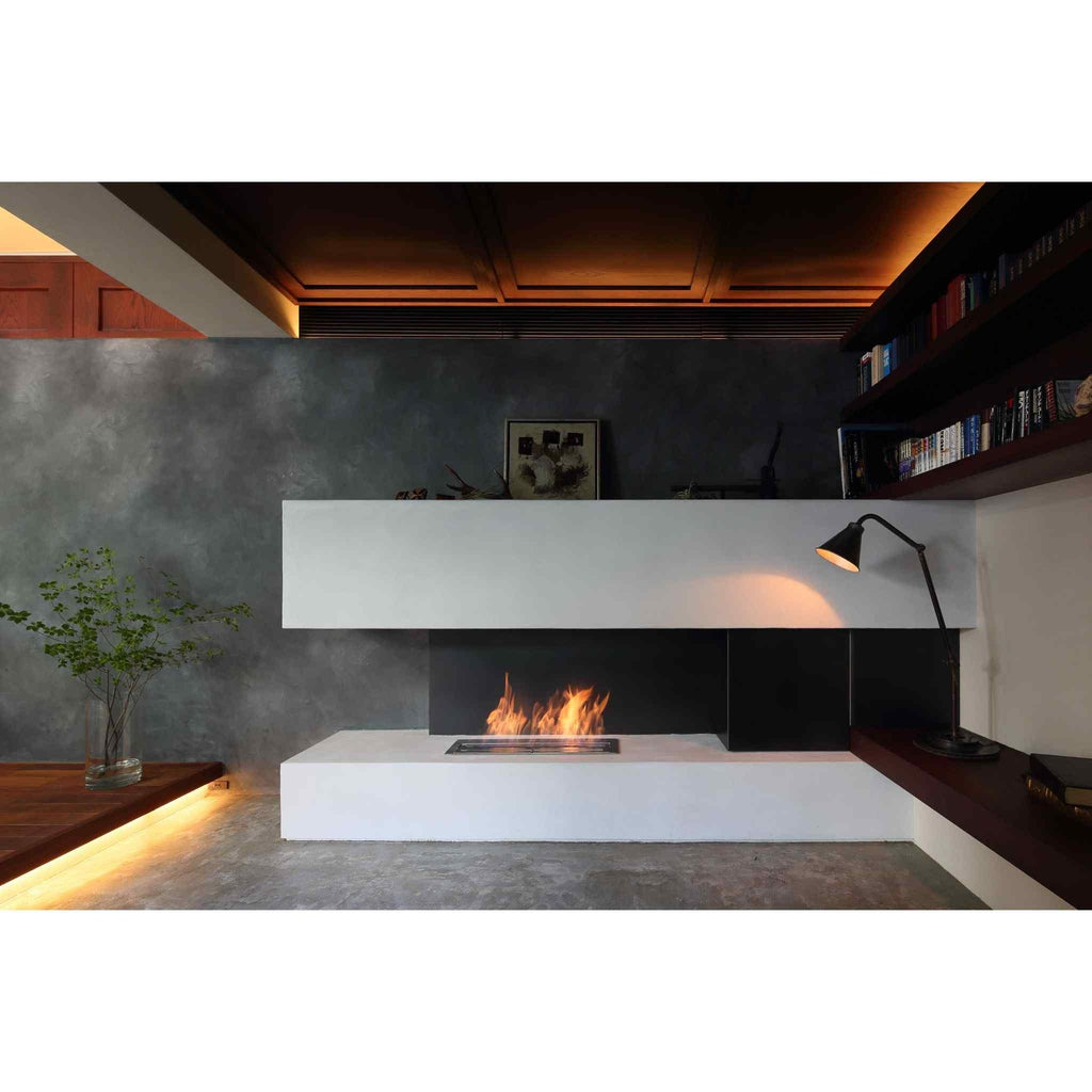 EcoSmart Fire XL700 ethanol burner integrated into a modern white fireplace with a black backdrop and glowing flames.