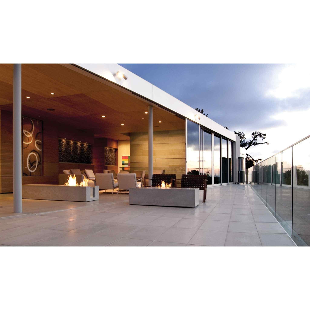 Two EcoSmart Fire XL700 ethanol burners in rectangular concrete casings on a modern outdoor terrace at dusk.