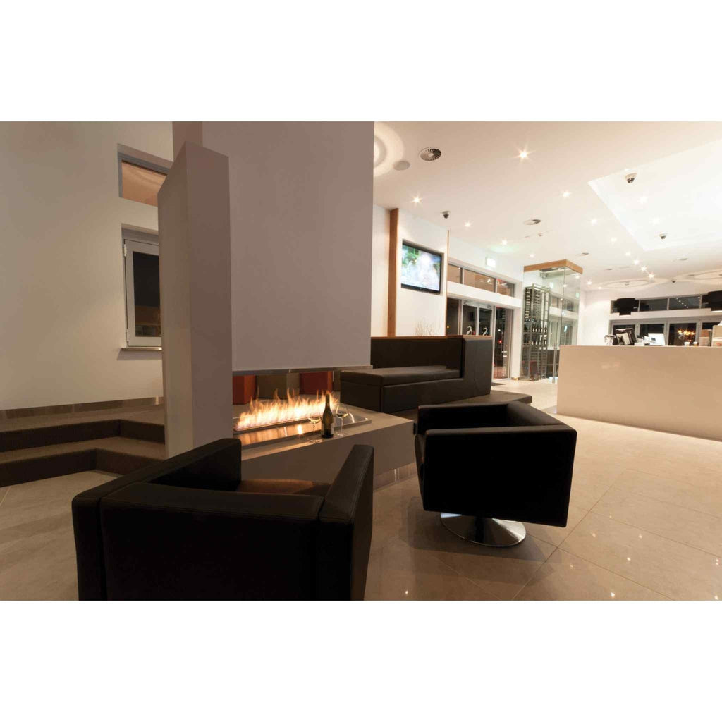 EcoSmart Fire XL900 ethanol burner with a linear flame in a modern lounge with black leather armchairs.