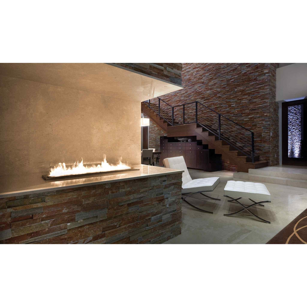 EcoSmart Fire XL900 ethanol burner inset into a stone-clad fireplace with a long, linear flame in a modern living room.