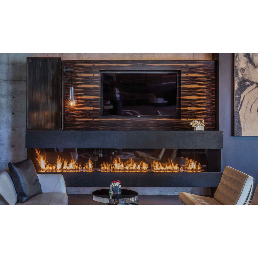 EcoSmart Fire XL900 ethanol burner installed in a long, black fireplace beneath a television on a dark wood wall.