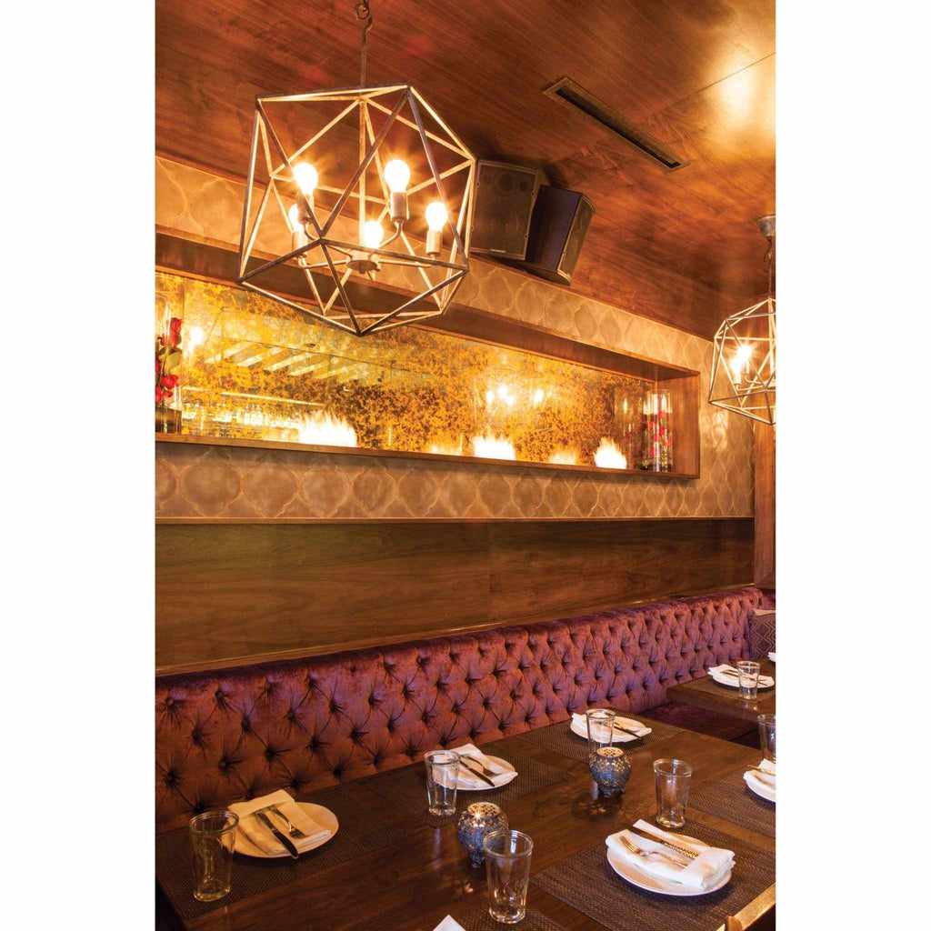 EcoSmart Fire XS340 ethanol burner integrated into a long, mirrored wall feature above a tufted purple banquet seat.