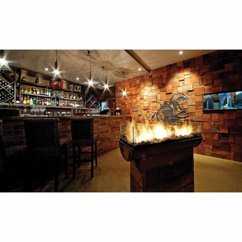 EcoSmart Fire XS340 ethanol burner with a glass screen and decorative stones, set in a rustic bar interior.