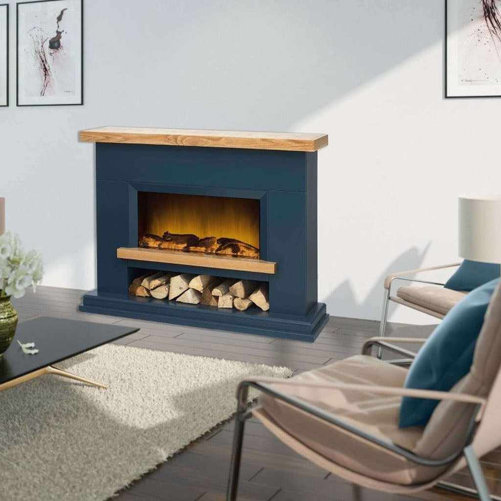 Flametek Brooklyn Electric Fireplace in navy blue with a natural wood mantel and log storage shelf in a living room.