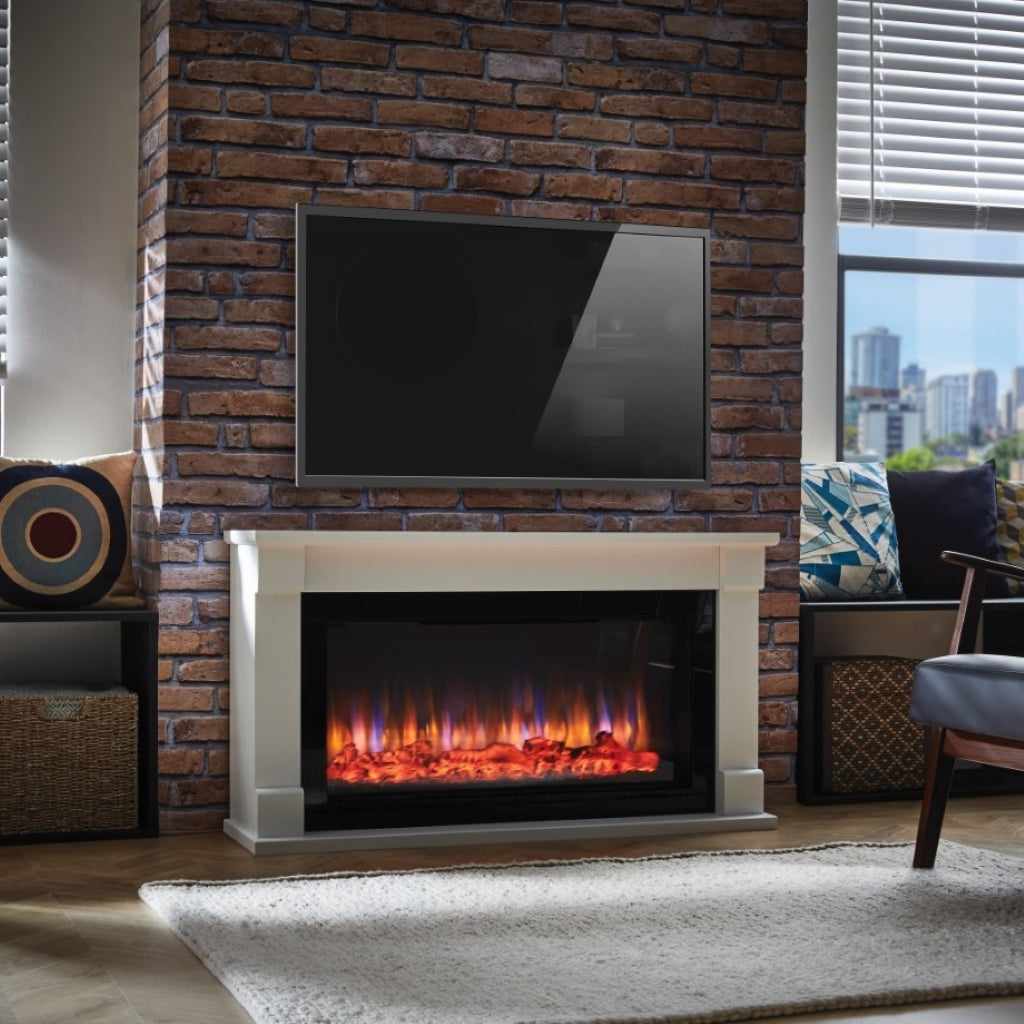 Suncrest Bradbury Electric Fireplace suite with a white surround and glowing flame effect against a brick chimney breast.
