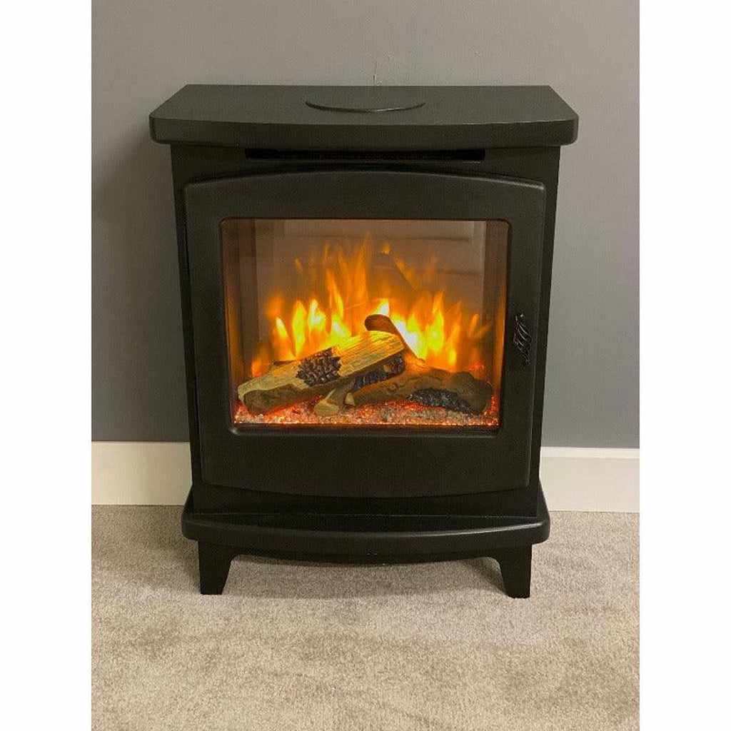 Suncrest Mitford electric stove in black with a large glass viewing window and realistic glowing log flame effect.